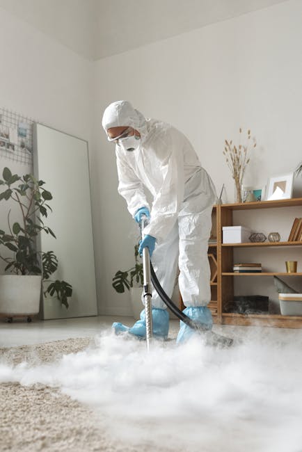 Close-up of a modern vacuum cleaner head and a section of an ornate, patterned carpet being thoroughly cleaned in a residential setting. The carpet features intricate floral designs in muted shades of beige, green, and orange, and appears clean and well-maintained. The vacuum cleaner is black and sleek, with a visible power switch, positioned centrally on the carpet, with a person’s feet in casual shoes partially visible in the background. Natural lighting highlights the cleanliness and detail of the surface. This image reflects surface cleaning and maintenance, aligning with the topic of avoiding hidden charges in Kingston carpet cleaning quotes and showcasing professional domestic cleaning services available through Kingstonuponthamescarpetcleaning.co.uk.